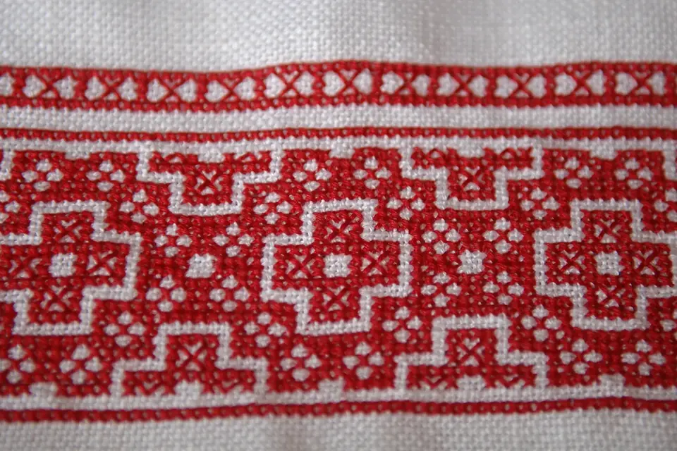 Broderie au point de croix en cours sur une toile, avec des croix colorées formant un motif