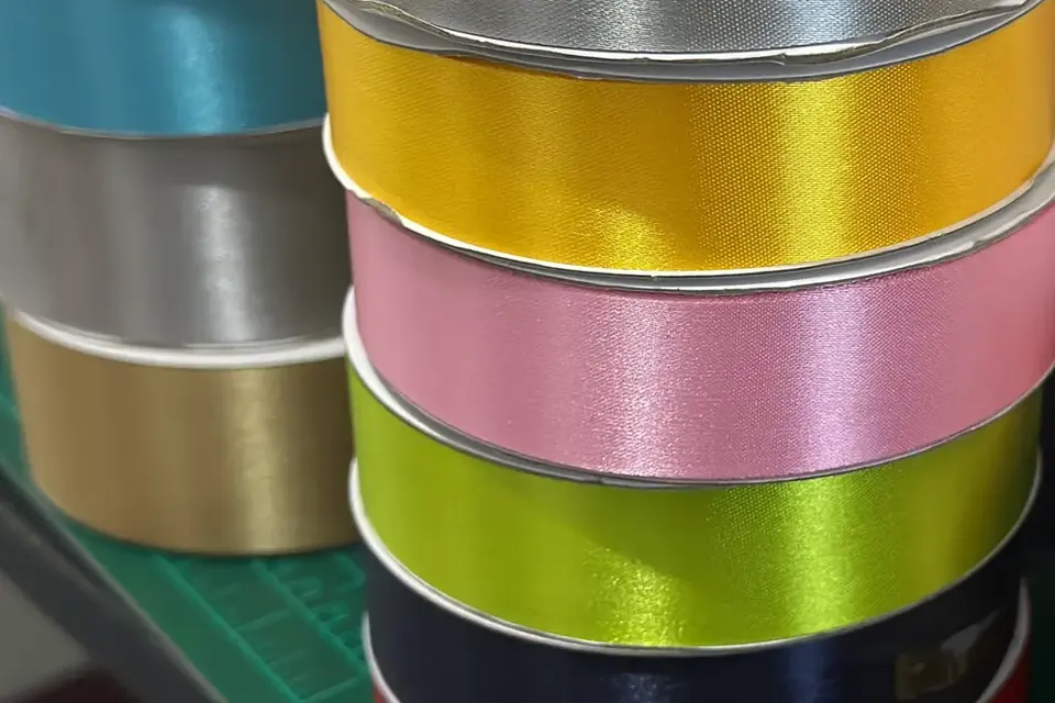 Rouleaux de rubans satinés de différentes couleurs alignés côte à côte